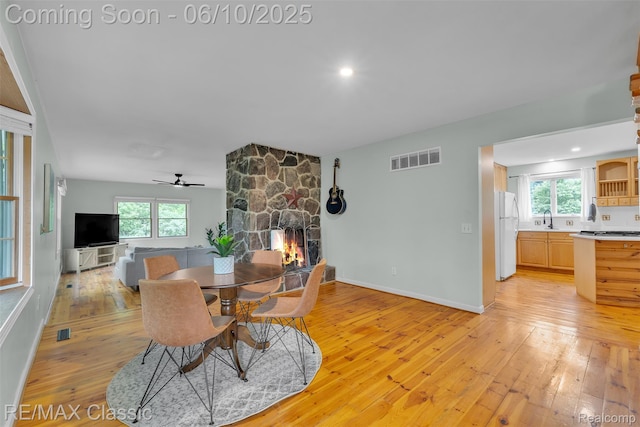917 Middle Rd, Highland, MI 48357 - dining area with light wood finished floors, a fireplace, plenty of natural light, a ceiling fan, and recessed lighting