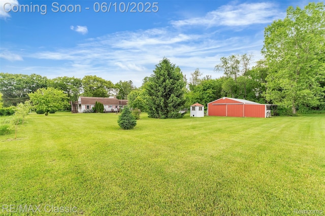 917 Middle Rd, Highland, MI 48357 - view of green lawn with an outbuilding, an outdoor structure, a garage, and view of wooded area
