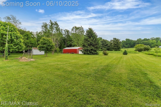917 Middle Rd, Highland, MI 48357 - view of grassy yard featuring an outbuilding and a detached garage