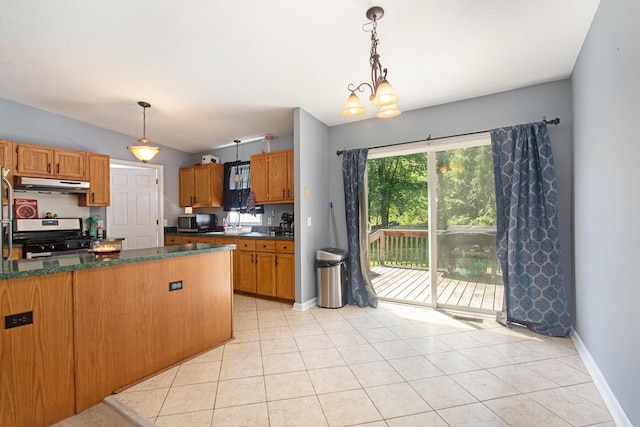 1417 Greenhouse Rd, Bangor, MI 49013 - kitchen with stainless steel appliances, under cabinet range hood, dark countertops, baseboards, and light tile patterned floors