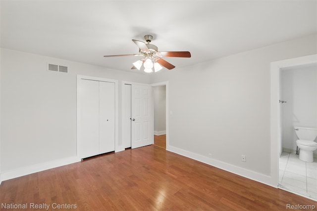 2430 Fox Hill Dr, Sterling Heights, MI 48310 - unfurnished bedroom featuring two closets, wood finished floors, baseboards, and ensuite bath