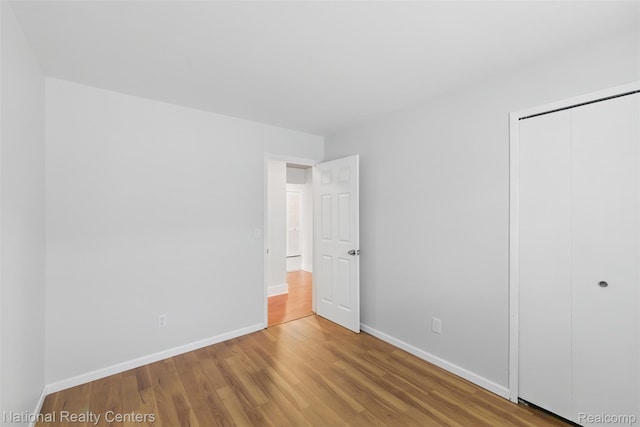 2430 Fox Hill Dr, Sterling Heights, MI 48310 - unfurnished bedroom featuring wood finished floors, a closet, and baseboards