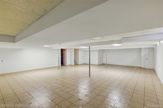 2430 Fox Hill Dr, Sterling Heights, MI 48310 - finished basement with stairs, baseboards, a paneled ceiling, and tile patterned flooring