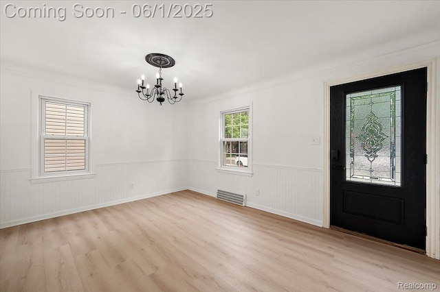 22923 Madison St, Dearborn, MI 48124 - entrance foyer featuring a chandelier, a wainscoted wall, wood finished floors, and ornamental molding