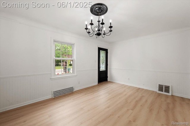 22923 Madison St, Dearborn, MI 48124 - spare room featuring a chandelier, wood finished floors, wainscoting, and crown molding