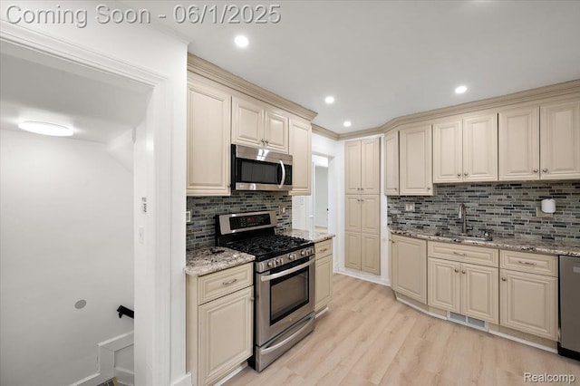 22923 Madison St, Dearborn, MI 48124 - kitchen with stainless steel appliances, cream cabinetry, a sink, decorative backsplash, and recessed lighting