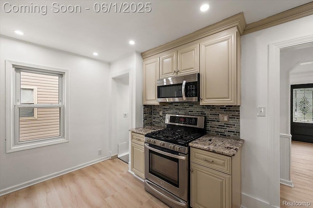 22923 Madison St, Dearborn, MI 48124 - kitchen featuring appliances with stainless steel finishes, cream cabinets, light wood-style flooring, backsplash, and light stone counters