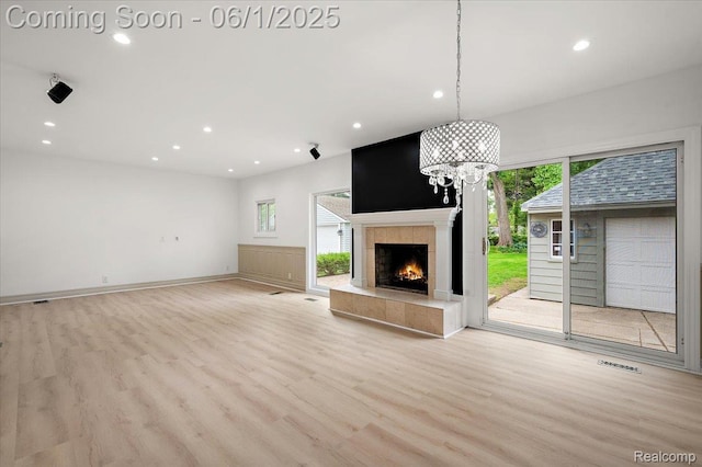 22923 Madison St, Dearborn, MI 48124 - unfurnished living room with recessed lighting, plenty of natural light, wood finished floors, and a tile fireplace