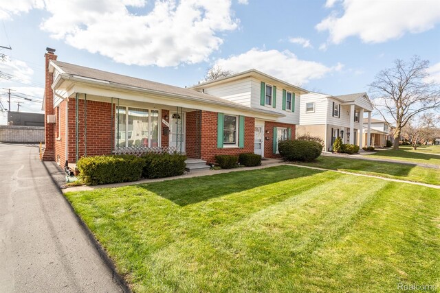 4811 Briarwood Ave, Royal Oak, MI 48073 - view of front of house featuring brick siding, a chimney, and a front yard