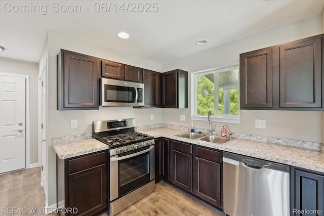 5200 Autumn Kirsten Dr, Fowlerville, MI 48836 - kitchen with stainless steel appliances, light wood-type flooring, dark brown cabinetry, light countertops, and recessed lighting