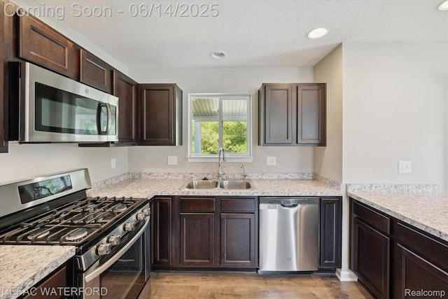 5200 Autumn Kirsten Dr, Fowlerville, MI 48836 - kitchen with stainless steel appliances, dark brown cabinets, light wood-style floors, light countertops, and a textured ceiling