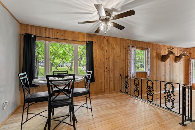 2240 S 13th St, Niles, MI 49120 - dining area with wooden walls, ceiling fan, and light wood-style floors