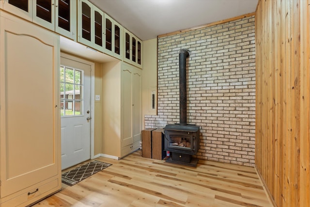 2240 S 13th St, Niles, MI 49120 - entrance foyer featuring brick wall, a wood stove, and light wood-type flooring