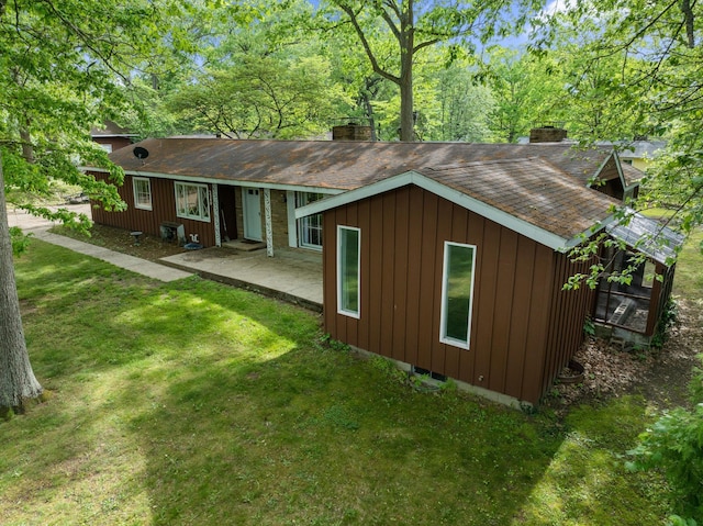 2240 S 13th St, Niles, MI 49120 - rear view of house featuring a chimney, a shingled roof, a lawn, and a patio area