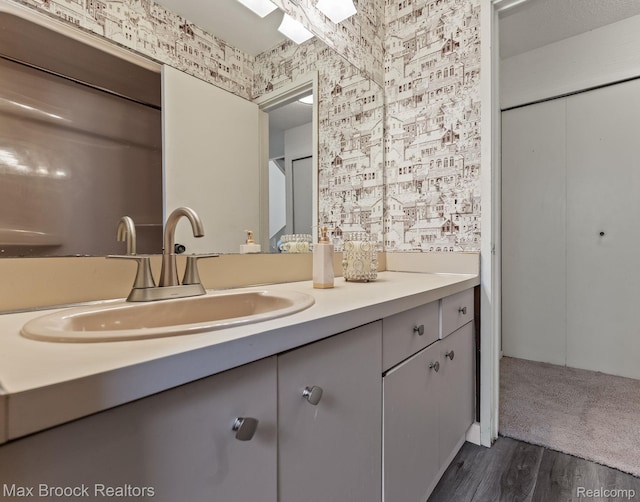 4355 Middleton Dr, Bloomfield Hills, MI 48302 - bathroom with wallpapered walls, vanity, and wood finished floors