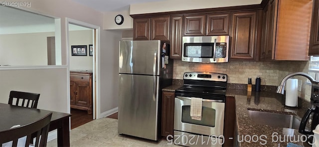 26312 Warrington St, Dearborn Heights, MI 48127 - kitchen featuring appliances with stainless steel finishes, a sink, tasteful backsplash, dark stone countertops, and dark brown cabinetry