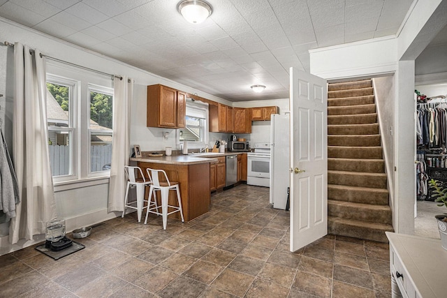 241 E Corey St, Bronson, MI 49028 - kitchen featuring appliances with stainless steel finishes, brown cabinets, a peninsula, light countertops, and dark stone finish floors
