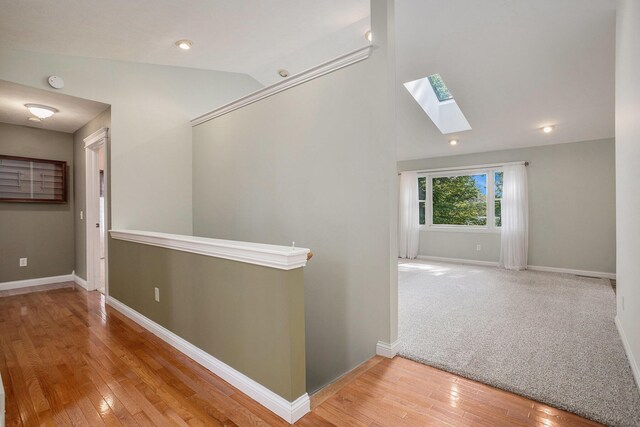 1407 S Dibble St, Hastings, MI 49058 - corridor with a skylight, vaulted ceiling, wood finished floors, baseboards, and an upstairs landing