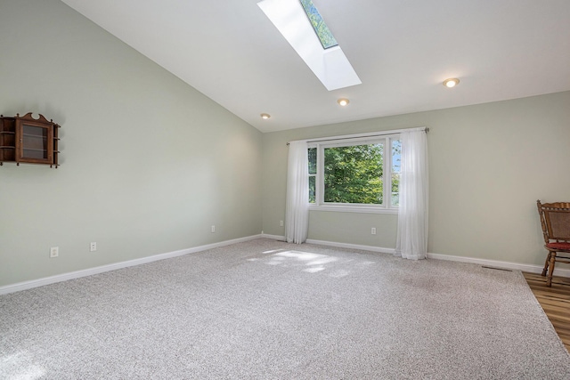 1407 S Dibble St, Hastings, MI 49058 - spare room with a skylight, baseboards, vaulted ceiling, and light carpet