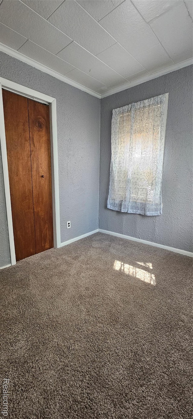 21117 Woodward St, Utica, MI 48035 - unfurnished bedroom with a textured wall, carpet floors, crown molding, and baseboards