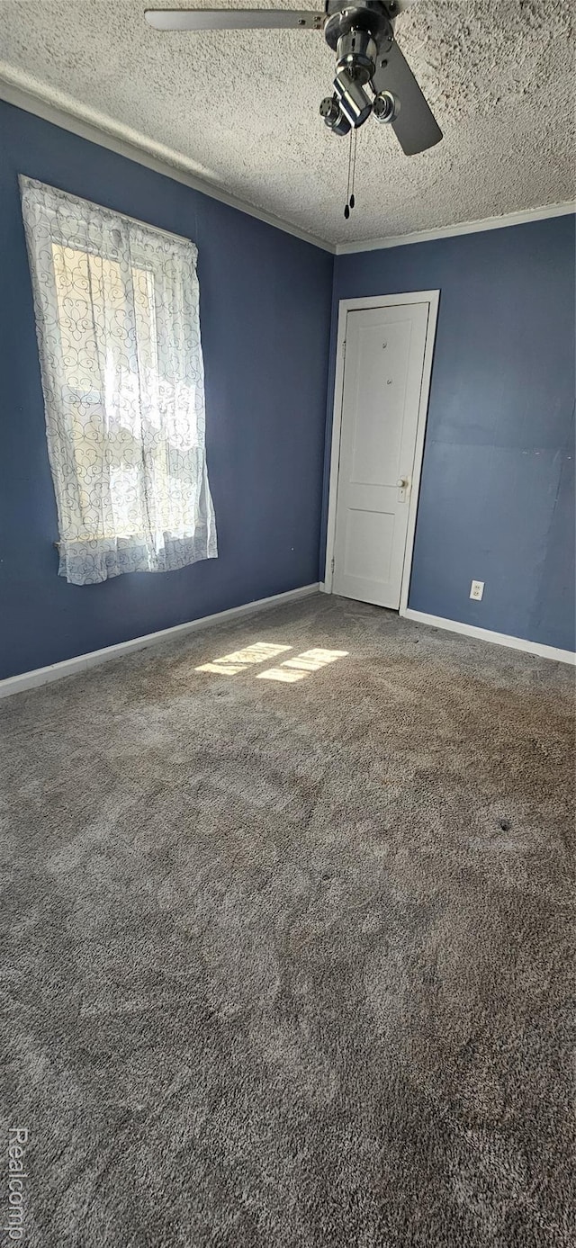 21117 Woodward St, Utica, MI 48035 - empty room with ceiling fan, a textured ceiling, carpet flooring, and baseboards