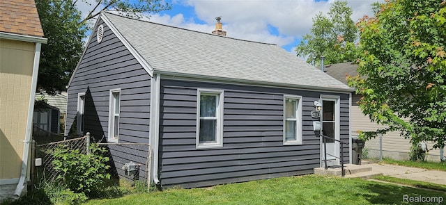21117 Woodward St, Utica, MI 48035 - view of side of home featuring a shingled roof and a chimney