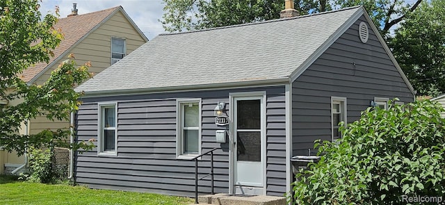 21117 Woodward St, Utica, MI 48035 - view of home's exterior featuring roof with shingles and a chimney