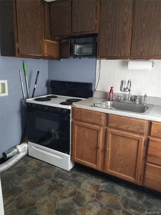21117 Woodward St, Utica, MI 48035 - kitchen with electric stove, stone finish flooring, black microwave, and light countertops