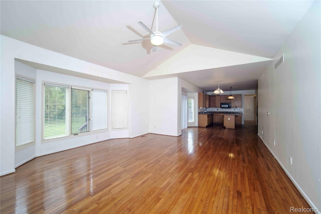 6169 Valley View Dr, Canton, MI 48187 - unfurnished living room featuring healthy amount of natural light, vaulted ceiling, ceiling fan, dark wood-style floors, and baseboards