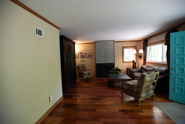 1204 Bydding Rd, Ann Arbor, MI 48103 - living area featuring crown molding, dark wood finished floors, a large fireplace, and baseboards