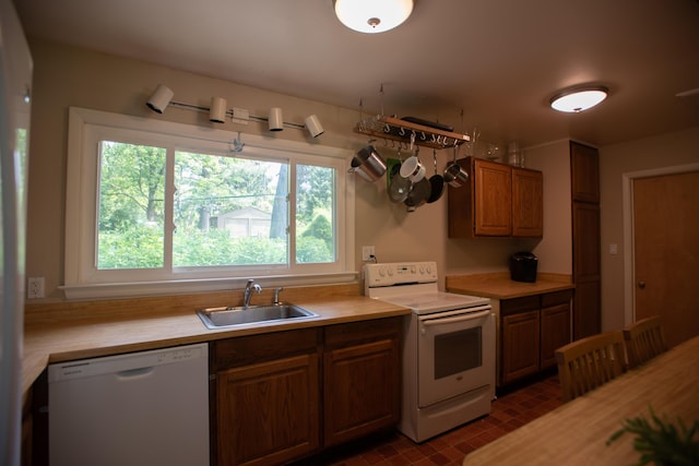 1204 Bydding Rd, Ann Arbor, MI 48103 - kitchen with white appliances, a sink, light countertops, brown cabinets, and brick patterned flooring