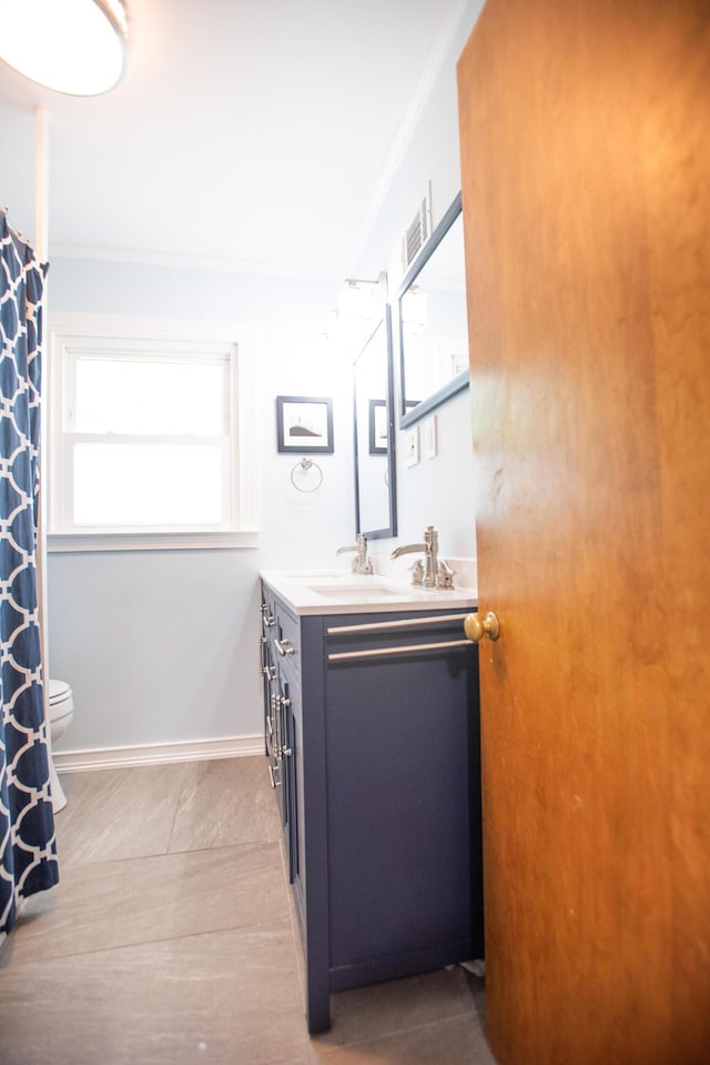 1204 Bydding Rd, Ann Arbor, MI 48103 - bathroom with double vanity, crown molding, toilet, and tile patterned flooring