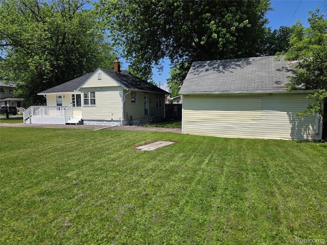 3263 Beechwood St, Monroe, MI 48162 - rear view of house featuring a yard, a wooden deck, and a chimney