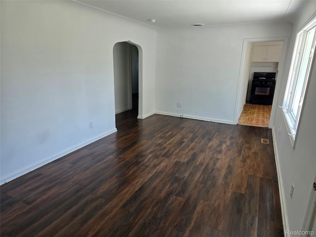3263 Beechwood St, Monroe, MI 48162 - empty room with dark wood finished floors and arched walkways