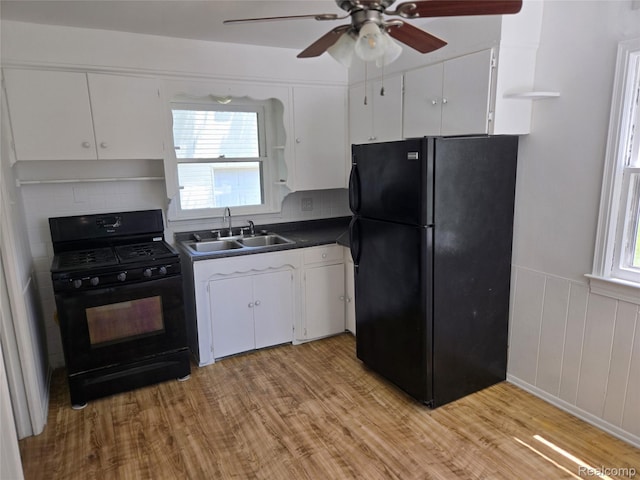 3263 Beechwood St, Monroe, MI 48162 - kitchen with black appliances, white cabinets, light wood-style floors, and decorative backsplash