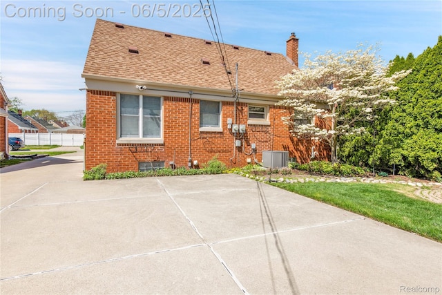 7639 Polk St, Taylor, MI 48180 - back of property with brick siding, roof with shingles, a chimney, and central AC