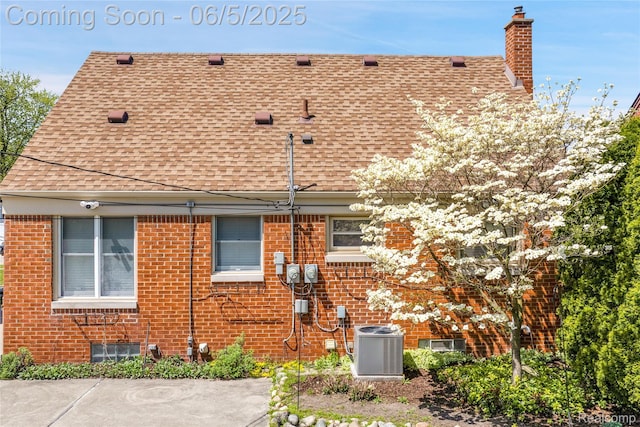 7639 Polk St, Taylor, MI 48180 - view of side of property with a shingled roof, cooling unit, a chimney, and brick siding
