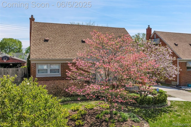 7639 Polk St, Taylor, MI 48180 - view of home's exterior featuring brick siding, a shingled roof, and a chimney