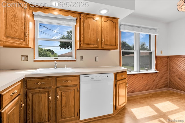 7639 Polk St, Taylor, MI 48180 - kitchen with dishwasher, a sink, light wood-style flooring, wooden walls, and light countertops