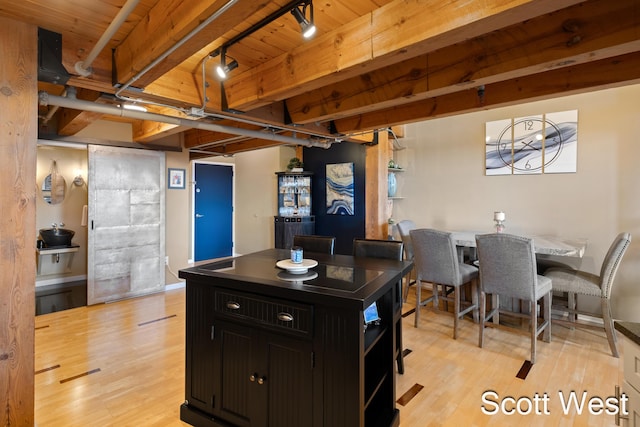 801 Monroe Ave NW Unit 402, Grand Rapids, MI 49503 - kitchen with dark cabinets, light wood-style floors, open shelves, rail lighting, and wood ceiling with exposed beams
