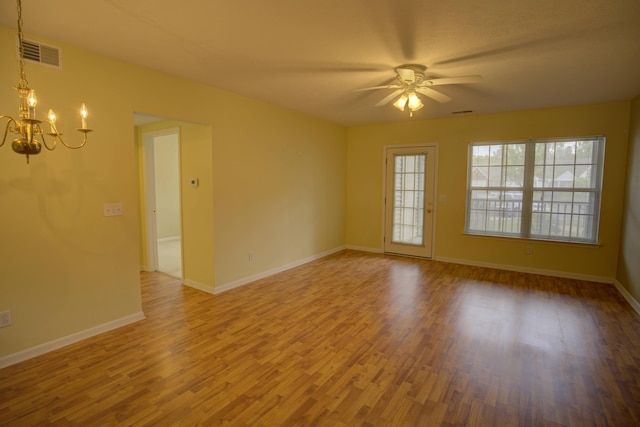920 Oakbrook Dr, Jackson, MI 49203 - unfurnished room with a chandelier, wood finished floors, ceiling fan, and baseboards