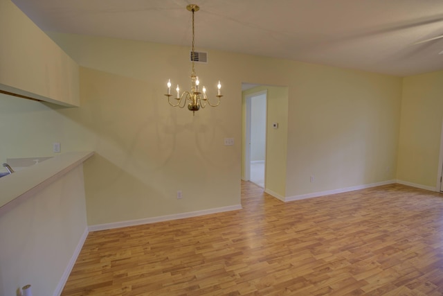 920 Oakbrook Dr, Jackson, MI 49203 - unfurnished dining area with light wood-type flooring, a chandelier, and baseboards
