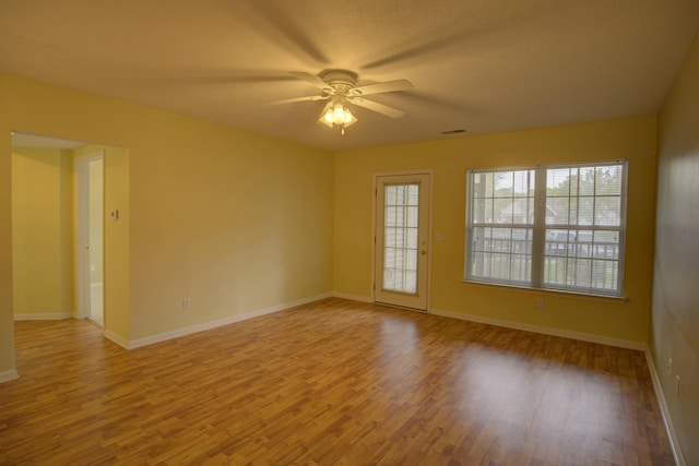 920 Oakbrook Dr, Jackson, MI 49203 - spare room with wood finished floors, a ceiling fan, and baseboards