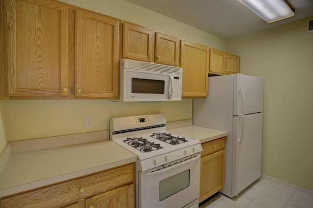 920 Oakbrook Dr, Jackson, MI 49203 - kitchen with white appliances, light tile patterned flooring, light countertops, light brown cabinets, and baseboards