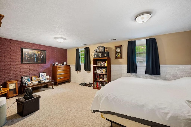 917 Kensington Dr, Niles, MI 49120 - bedroom featuring wainscoting, brick wall, carpet floors, and a textured ceiling