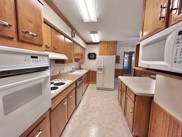 818 W Chestnut St, Morenci, MI 49256 - kitchen with white appliances, a sink, brown cabinets, light countertops, and wainscoting