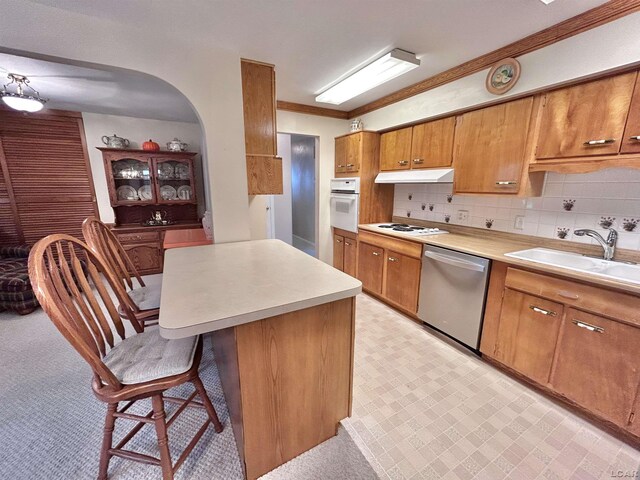 818 W Chestnut St, Morenci, MI 49256 - kitchen featuring white appliances, brown cabinets, a breakfast bar area, light countertops, and arched walkways