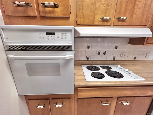 818 W Chestnut St, Morenci, MI 49256 - kitchen with white appliances, decorative backsplash, brown cabinetry, light countertops, and under cabinet range hood