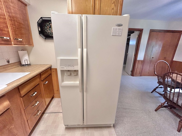 818 W Chestnut St, Morenci, MI 49256 - kitchen featuring white fridge with ice dispenser, brown cabinetry, decorative backsplash, light countertops, and light carpet