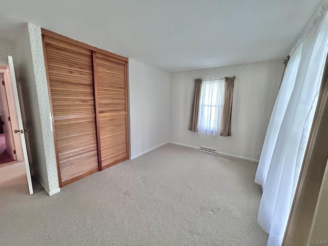 818 W Chestnut St, Morenci, MI 49256 - unfurnished bedroom featuring carpet floors, a closet, wallpapered walls, and baseboards